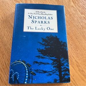 “The Lucky One" by Nicholas Sparks, a hardcover romance novel.